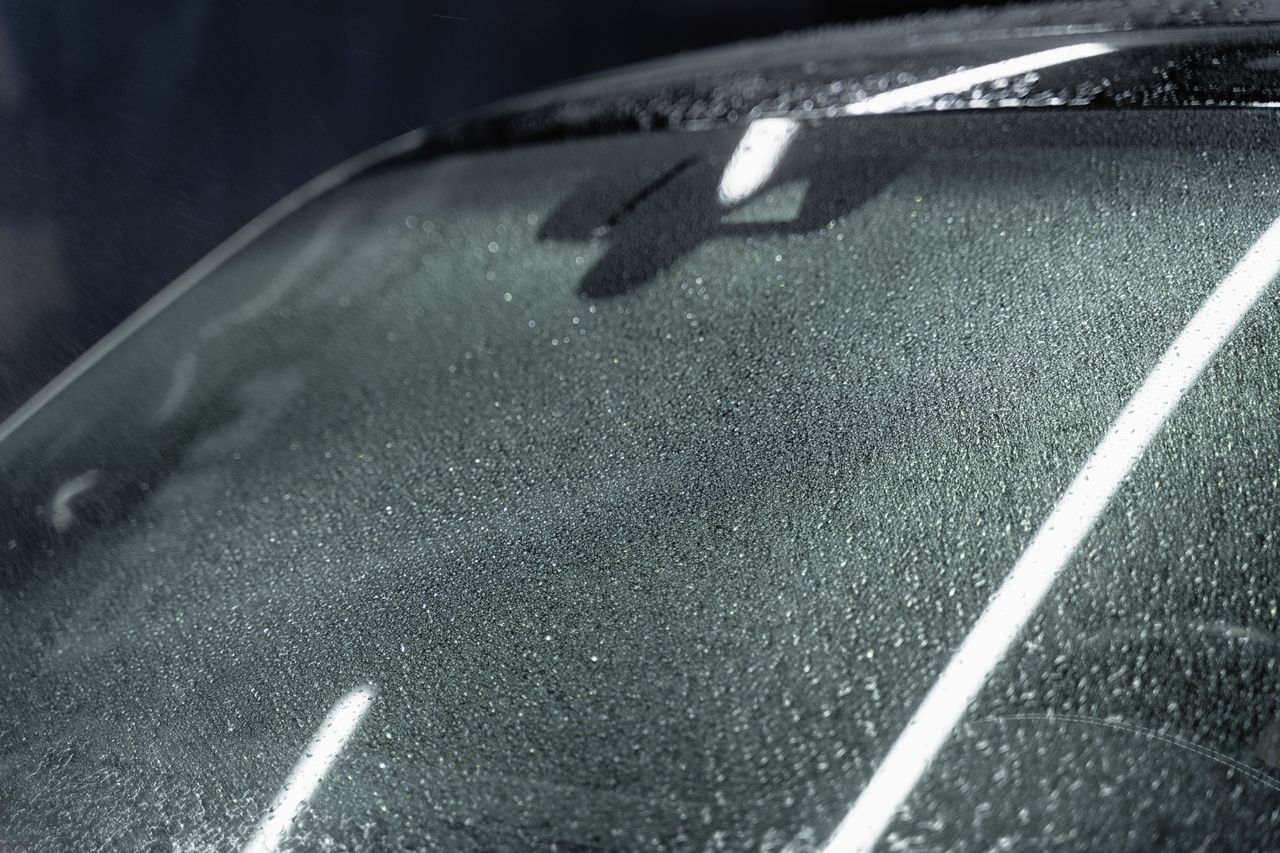 Detailed focus on a car windshield with raindrops, highlighting texture and refraction.